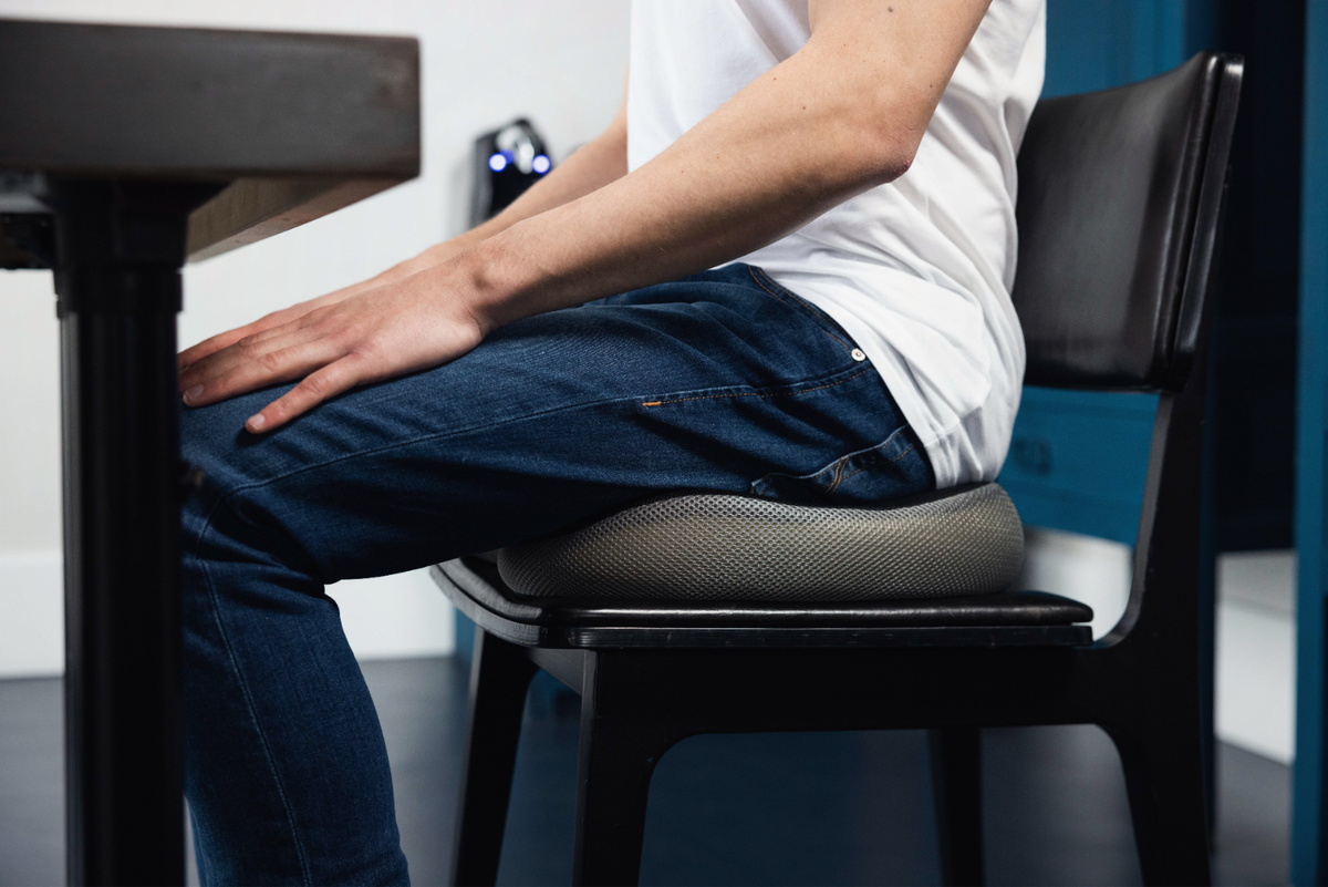 Man zit aan bureau op Ringkussen Monviso op een houten stoel