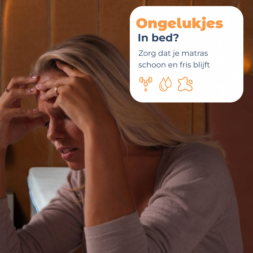 Vrouw met hoofd in de handen na een ongelukje in bed zonder matrasbeschermer