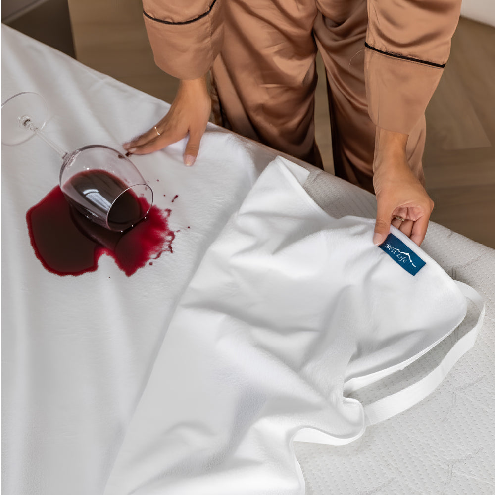 Glas rode wijn omgevallen op Matrasbeschermer Garda op bed