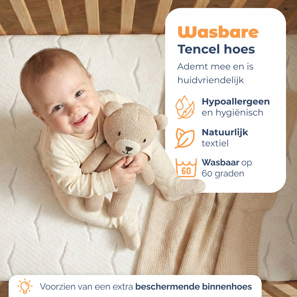 Lachende baby met knuffel op Babymatras Nimba met wasbare Tencel hoes, wasbaar op 60 graden