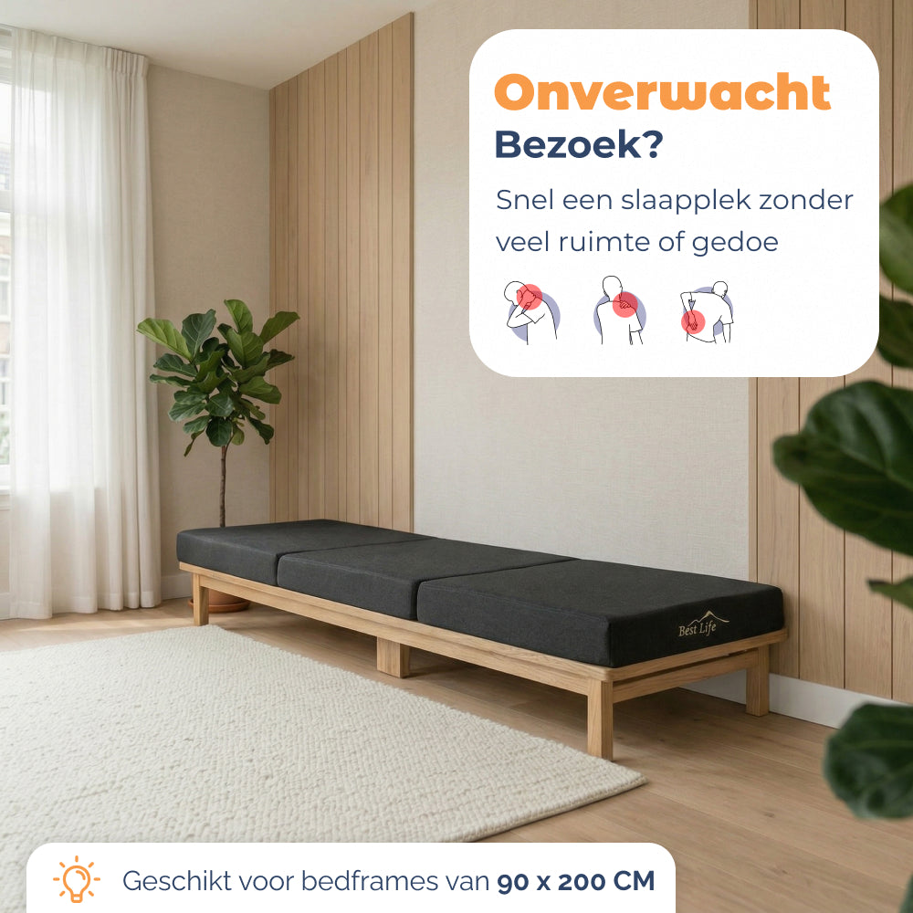 Vouwmatras Sella uitgevouwen op een houten bedframe als extra slaapplek voor bezoek