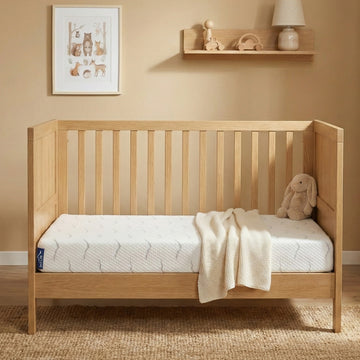 Babymatras Nimba in een houten ledikant in de babykamer